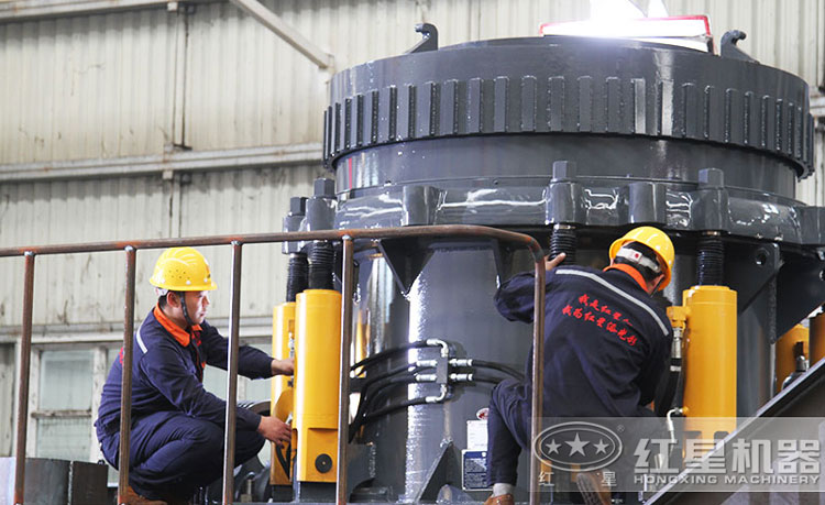 工作人員檢測(cè)圓錐破碎機(jī)，保障生產(chǎn)的設(shè)備都有高質(zhì)量